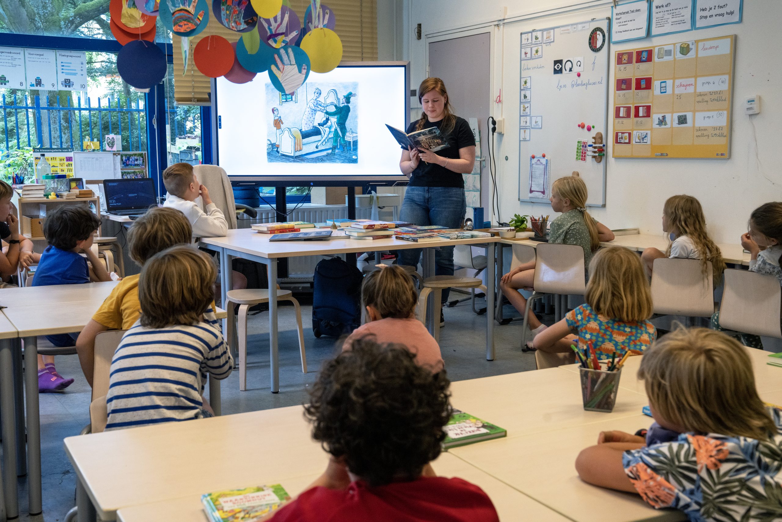 Docent praat over boeken voor de klas