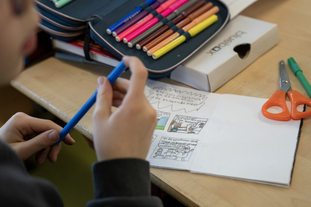 Leerling maakt een tekening naar aanleiding van een boek.