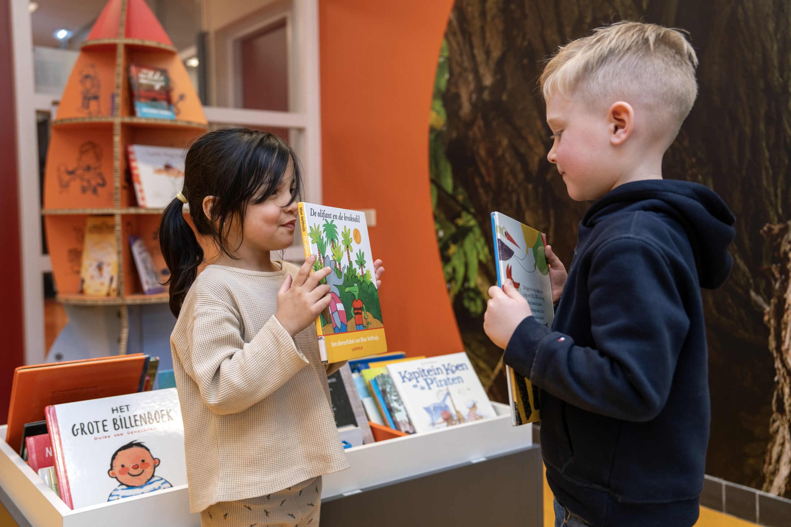 Kinderen houden prentenboek vast en laten deze aan elkaar zien 