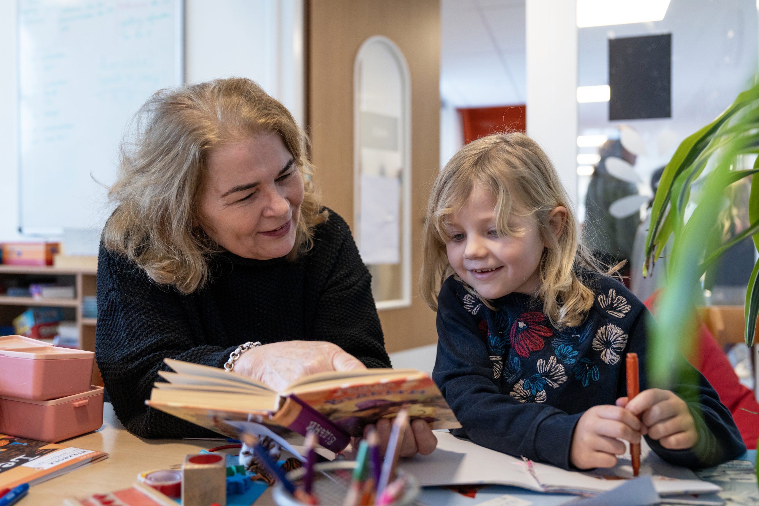 Vrouw leest boek met kind 