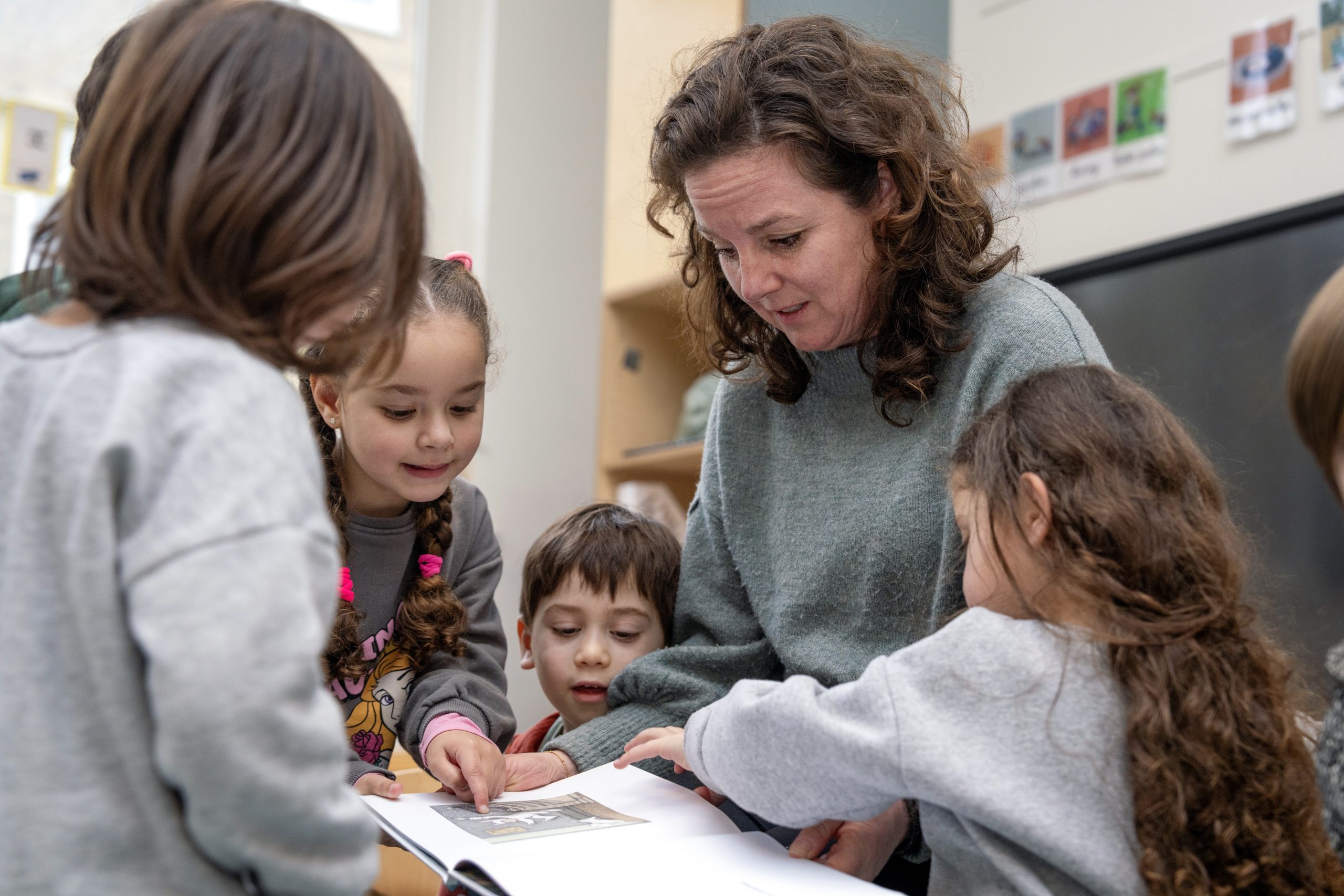 Kinderen worden voorgelezen uit prentenboek.