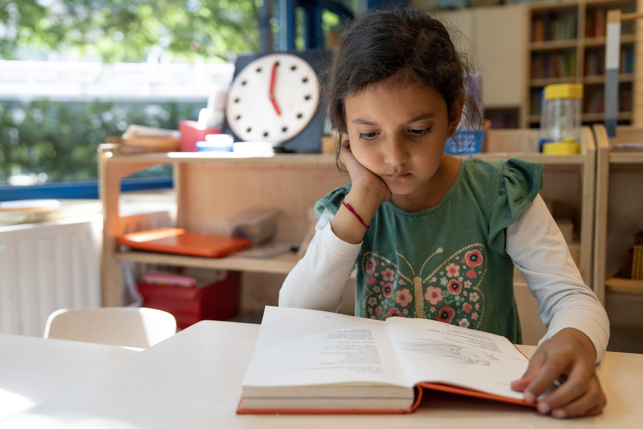 Meisje leest een boek in een klaslokaal - rijke thema's