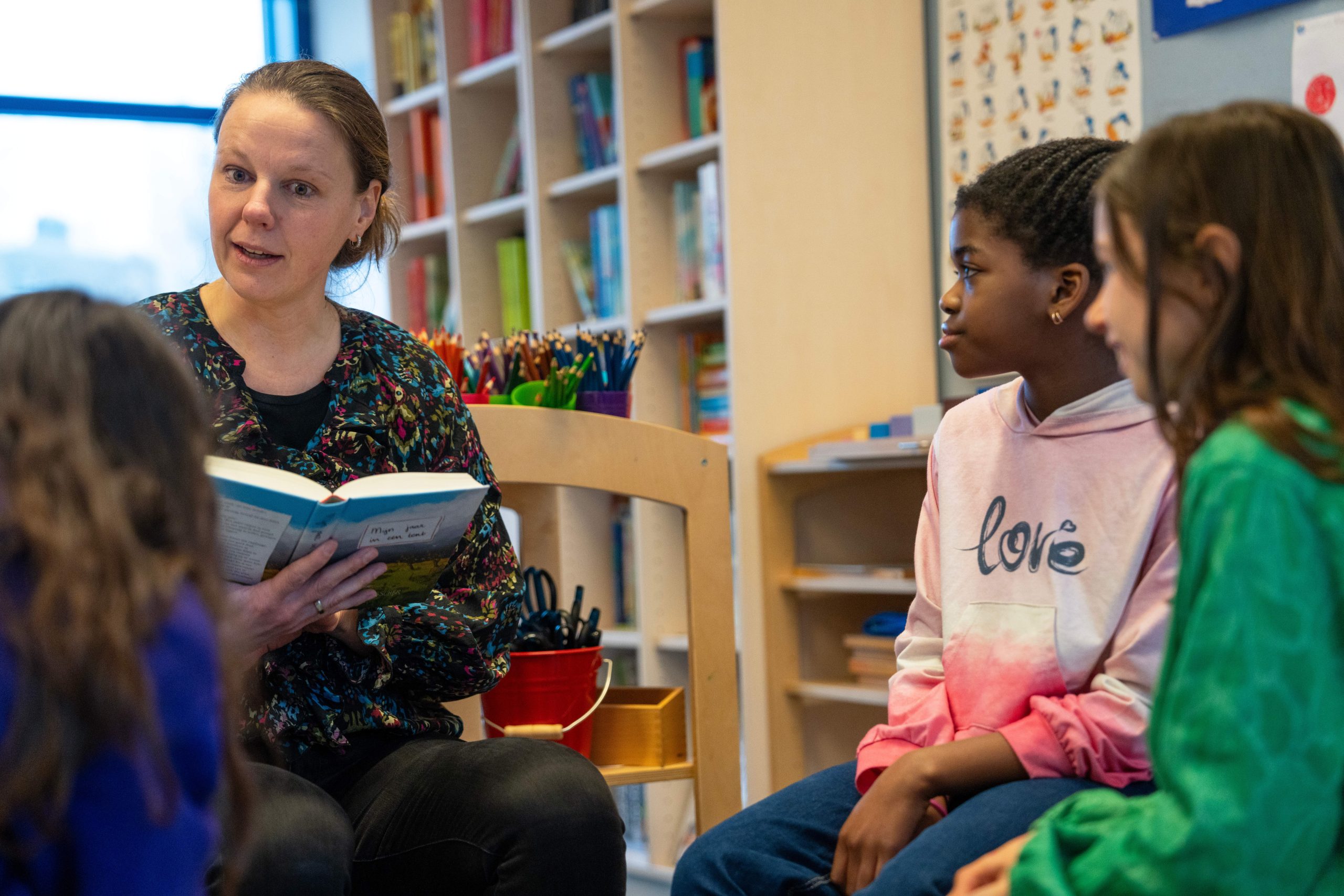 Vrouw leest voor aan groep kinderen 