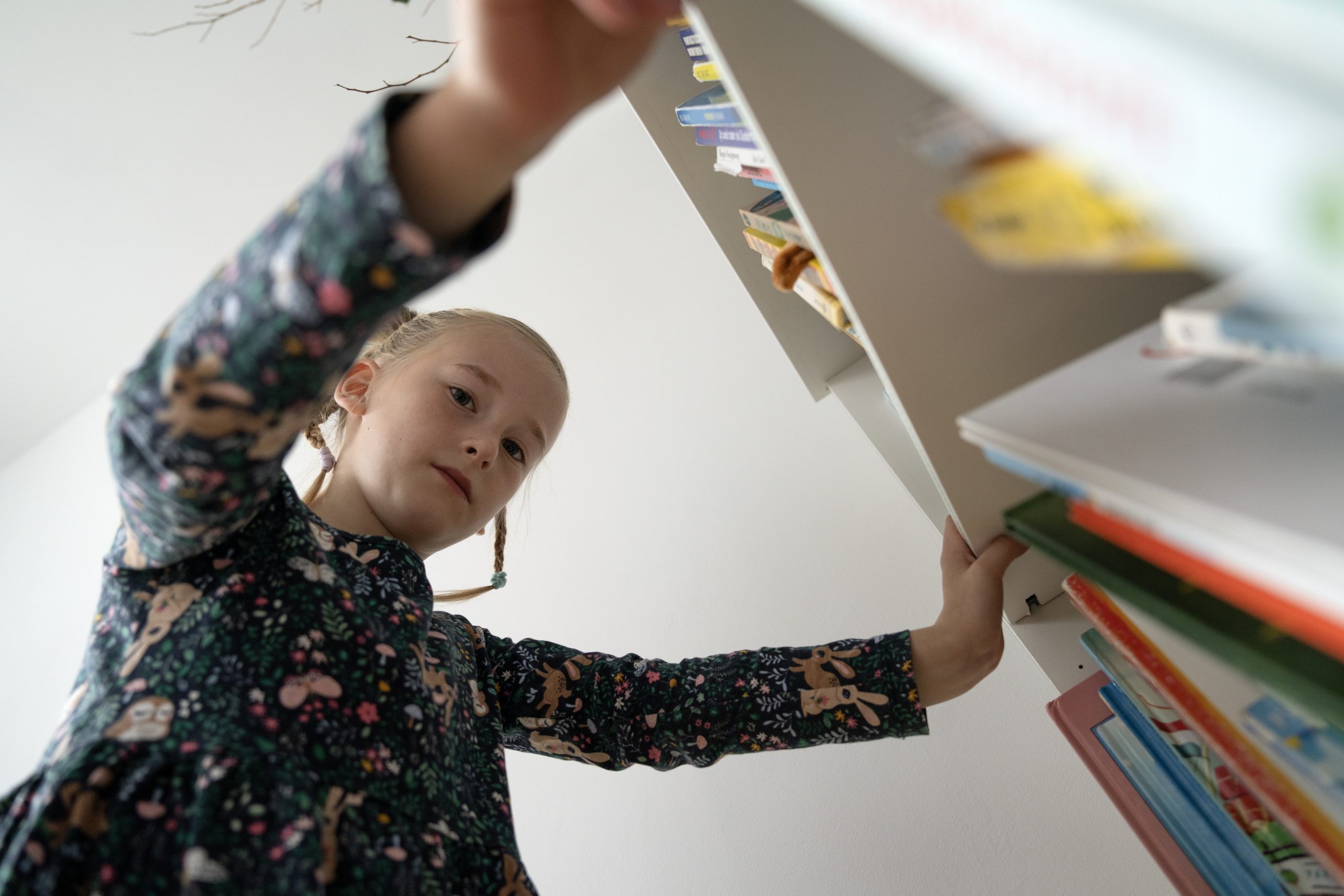 Meisje kijkt in boekenkast - de leesontwikkelingen volgen